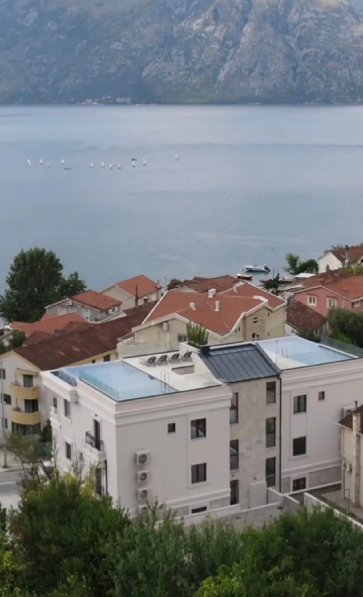 Completed residential building with rooftop pools above the Bay of Kotor.